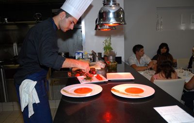 Le chef dresse les assiettes devant les clients du Garage, près de Marseille au bord de l'étang de Berre